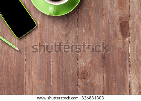 Office wooden desk with smartphone and coffee cup. Top view with copy space