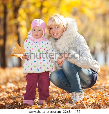 Mother and daughter in the autumn park