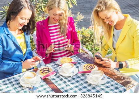 Women looking at their smartphones and smiling