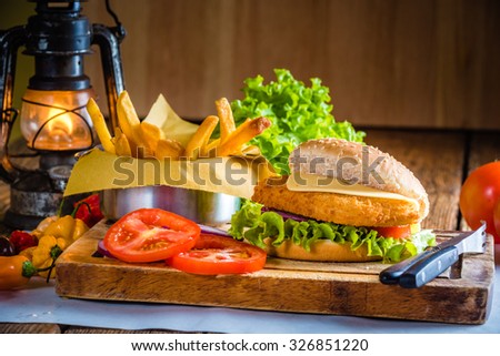 Juicy and delicious looking chicken burger with fried potatoes