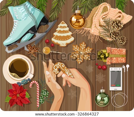 Workplace concept. Top view with textured table, skating, gingerbread, fir branches, Christmas toys, balls, hands, Christmas decorations, snowflakes, coffee cup, candy, lollipop, flower, gift