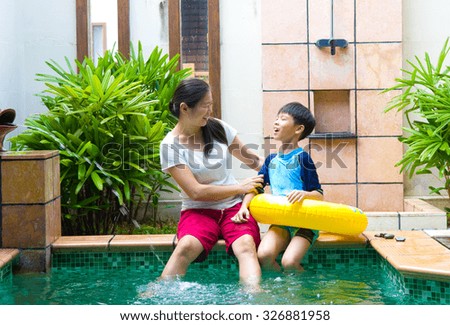 Happy chinese Asian Family Playing in the pool
