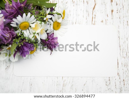 Wild Flowers with card on a wooden background