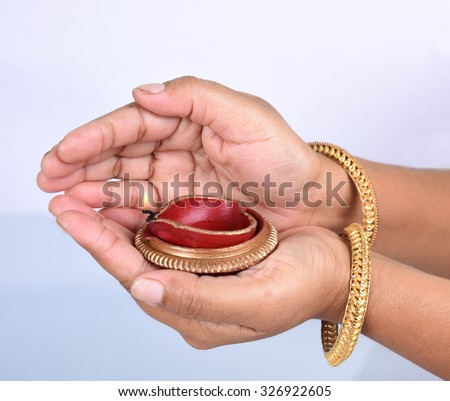 woman hands holding indian oil lamp in diwali festival of lights.
