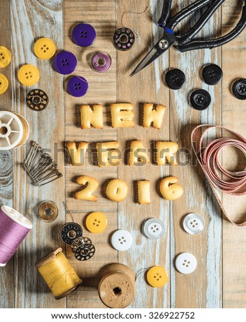 ABC Cookie in the form of word NEW YEAR 2016 and sewing tools on vintage wooden background. Copy-Space