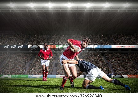 Rugby fans in arena against rugby players tackling during game Royalty-Free Stock Photo #326926340