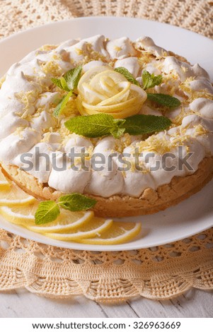 Gourmet Lemon cake with meringue and mint close-up on a plate. Vertical
