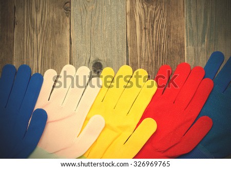 set of multicolored construction gloves on an old bench. instagram image filter retro style