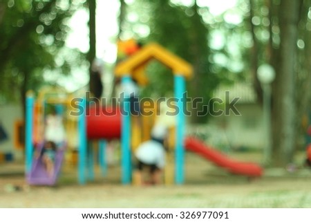 blurred picture of a playground at a city park .