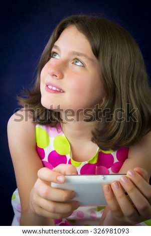 Portrait of beautiful little girl with cell phone. Smiling