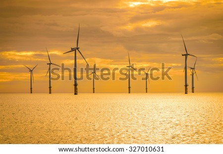 Sunset Offshore Wind Turbine in a Wind farm under construction off the England coast Royalty-Free Stock Photo #327010631