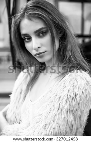 hipster fashion woman model posing on  city street background. black and white photo