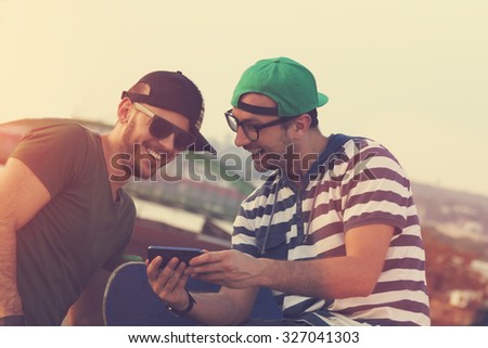 Young urban guys using a smartphone outdoors.