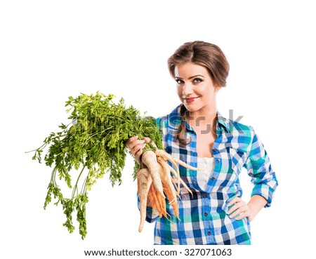 Beautiful young woman with carrots and parsley. Studio shot on white background.