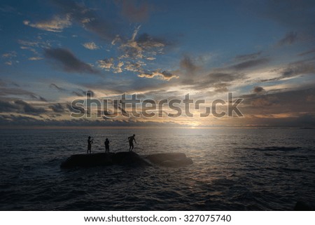 Three men fishing on the sea while sunset in Rayong ,Thailand.