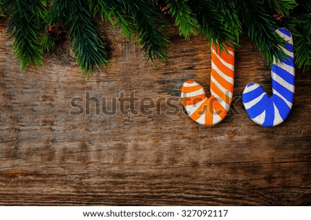wooden background with wooden Christmas shaped stick and the branches of the Christmas tree for Christmas. toning. selective focus
