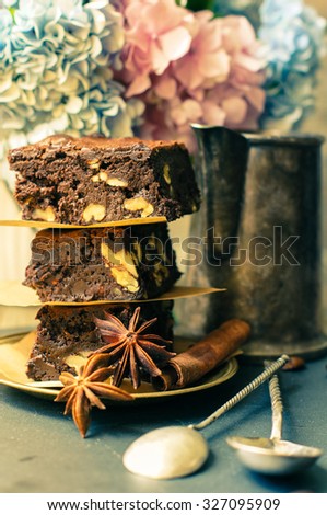Home made brownies on vintage plate with vintage silverware and hydrangea flowers. Toned picture