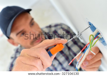 Electrician with exposed wiring Royalty-Free Stock Photo #327106130