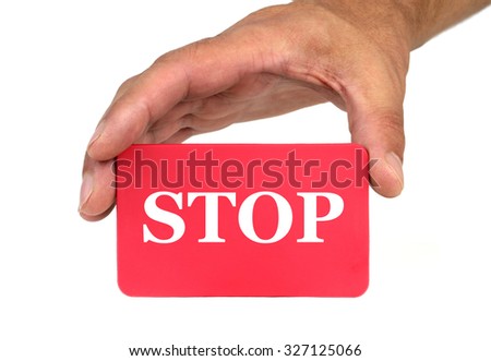 Hand holding and showing a red card with " STOP " text
