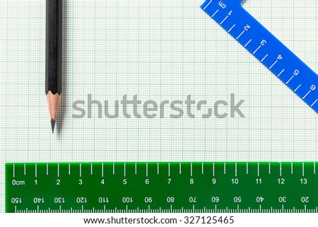Pencil and Ruler on green graph paper with copy space