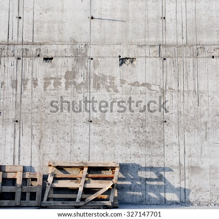 Grey concrete wall with wood palette. Construction site. Sunset.