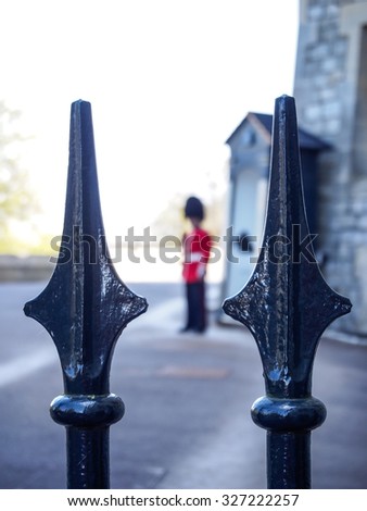steel fence of Windsor castle with a royal guard in background, UK