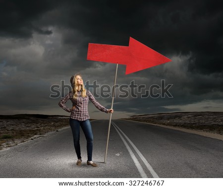 Young girl with arrow signbord in empty room