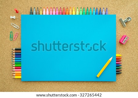 Top view of education and art supplies on cork table with empty space color paper