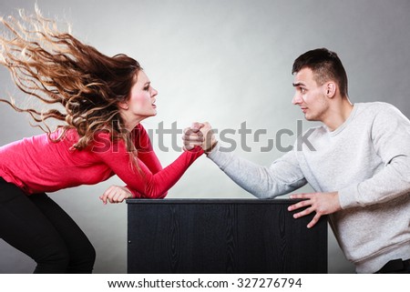 Partnership relationship concept. Girlfriend confronts his boyfriend. Woman and man arm wrestling challenge between young couple Royalty-Free Stock Photo #327276794