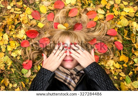 girl lying on the autumn leaves Royalty-Free Stock Photo #327284486