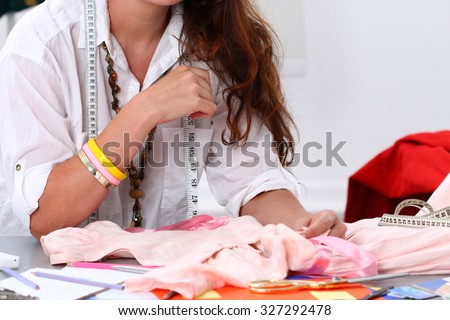 Close up of woman dressmaker hands sewing some closes