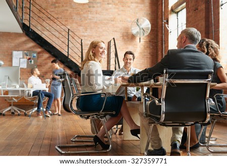 Exciting boardroom meeting with business people in trendy office space Royalty-Free Stock Photo #327359771