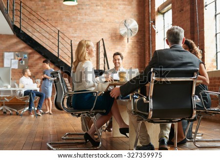 Exciting boardroom meeting with business people in trendy office space Royalty-Free Stock Photo #327359975