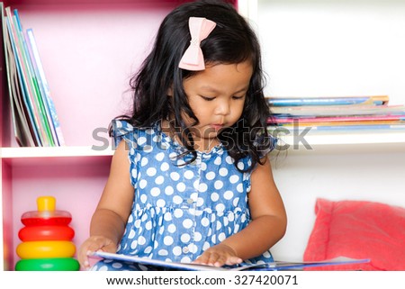 Child read, cute little girl reading a book on bookshelf background