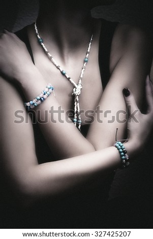 woman bust with bracelets and necklaces, closeup, indoor shot, small amount of grain added Royalty-Free Stock Photo #327425207