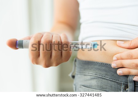 medicine, diabetes, glycemia, health care and people concept - close up of woman hands making injection with insulin pen or syringe Royalty-Free Stock Photo #327441485