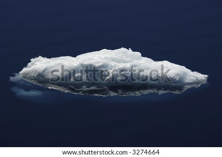 A beautiful ice floe reflecting in calm Antarctic waters. Picture was taken near the Peninsula.
