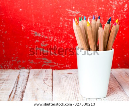 Still life, business, education concept. Crayons in a mug on a wooden table. Selective focus, copy space background
