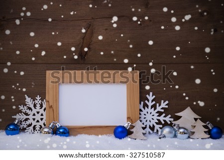 Blue Christmas Decoration On White Snow. Christmas Tree Balls, Snowflakes And Christmas Tree. Picture Frame With Copy Space For Advertisement. Rustic, Vintage Brown Wooden Background. 