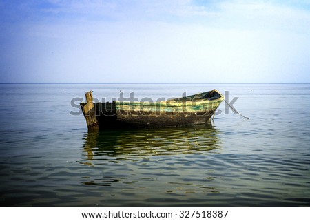 Boat at anchor in sea high contrasted with vignetting effect