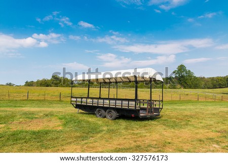 Covered wagon with white top in farm fields.