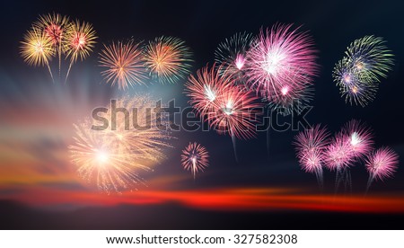 The silhouette of a young girl watching a fireworks display during sunset. Beautiful firework display for celebration. Sunset background. Sunset with firework background. Hand pointed fireworks.