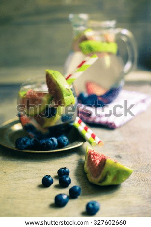 Cold lemonade with figs, blueberry, and plums. Toned picture
