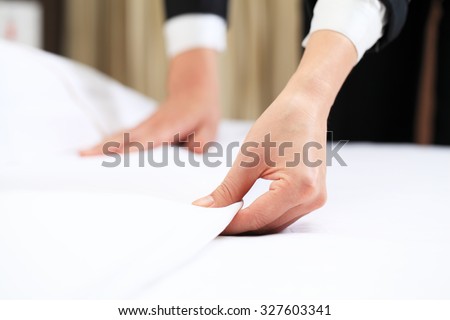 Hands Making Bed from Hotel Room Service Royalty-Free Stock Photo #327603341