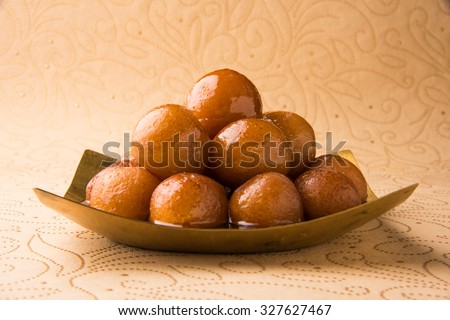 indian sweet gulab jamun in square shape brass plate, closeup view Royalty-Free Stock Photo #327627467