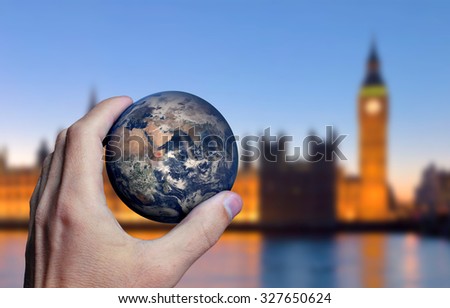 Earth planet in male hand. London city background. Elements of this image furnished by NASA