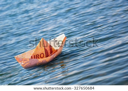 Ten euro origami boat on the sea.