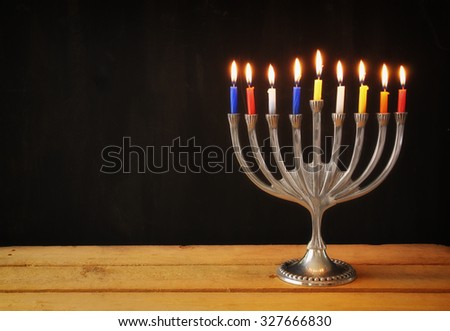 Image of jewish holiday Hanukkah background with menorah (traditional candelabra) Burning candles over black background 
