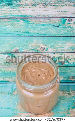 Peanut butter in a mason jar over wooden background