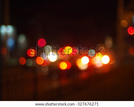 Abstract colored lights of the night city. Blurred image of light from the glare of headlights, traffic lights and windows for use as a background.